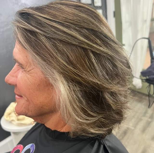 Side view of a layered brown bob with silver strands around the face and through the lengths