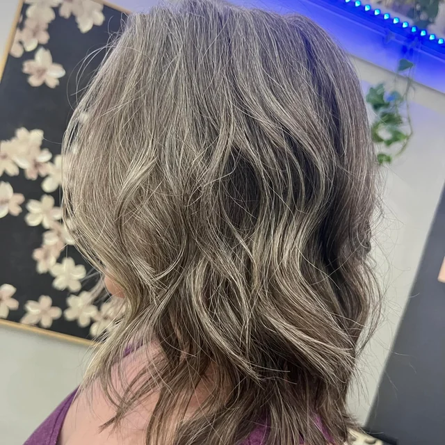 Shoulder-length waves with silver and lighter ribbons through darker hair
