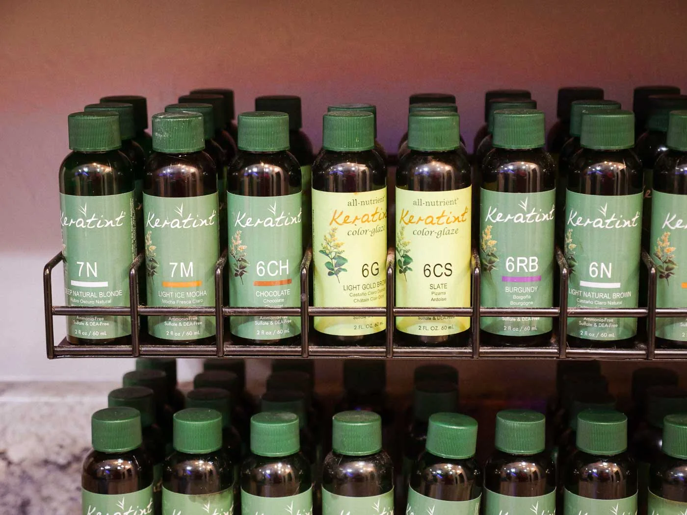 Rows of green color bottles on a salon shelf