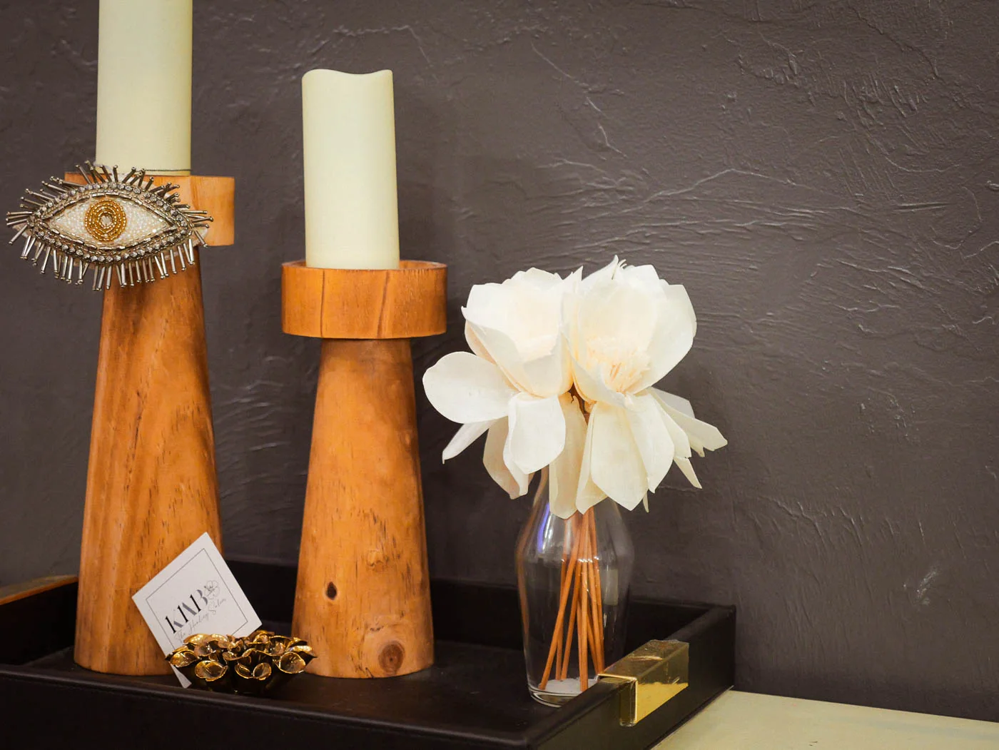 Candles and a white flower on a salon side table