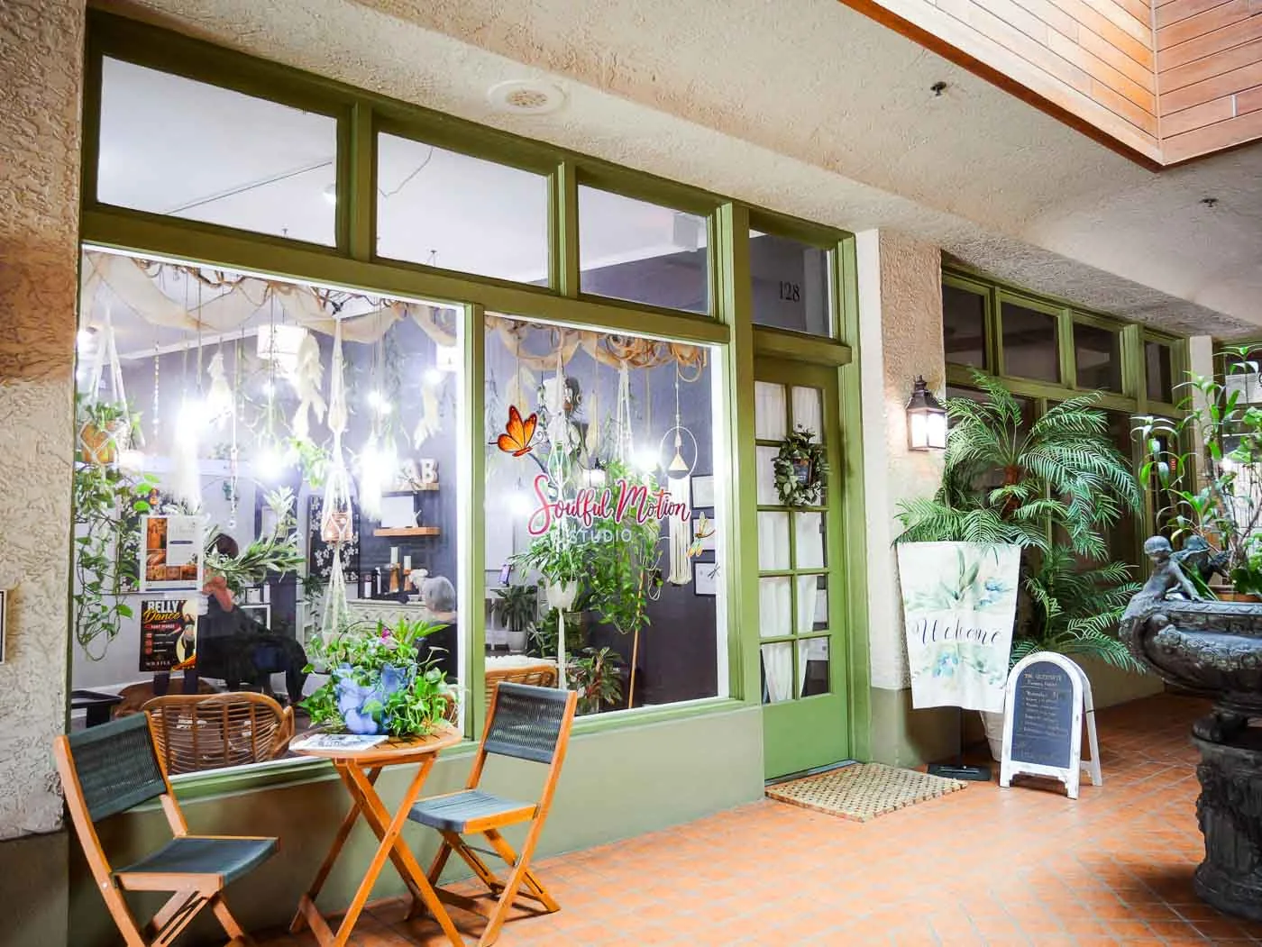 The salon’s green-framed front windows and welcome sign in Kraaz Square